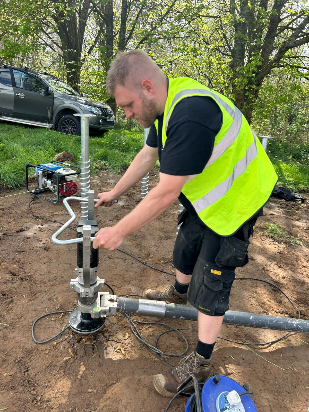 Ground Down installer in hi-vis working with installation equipment